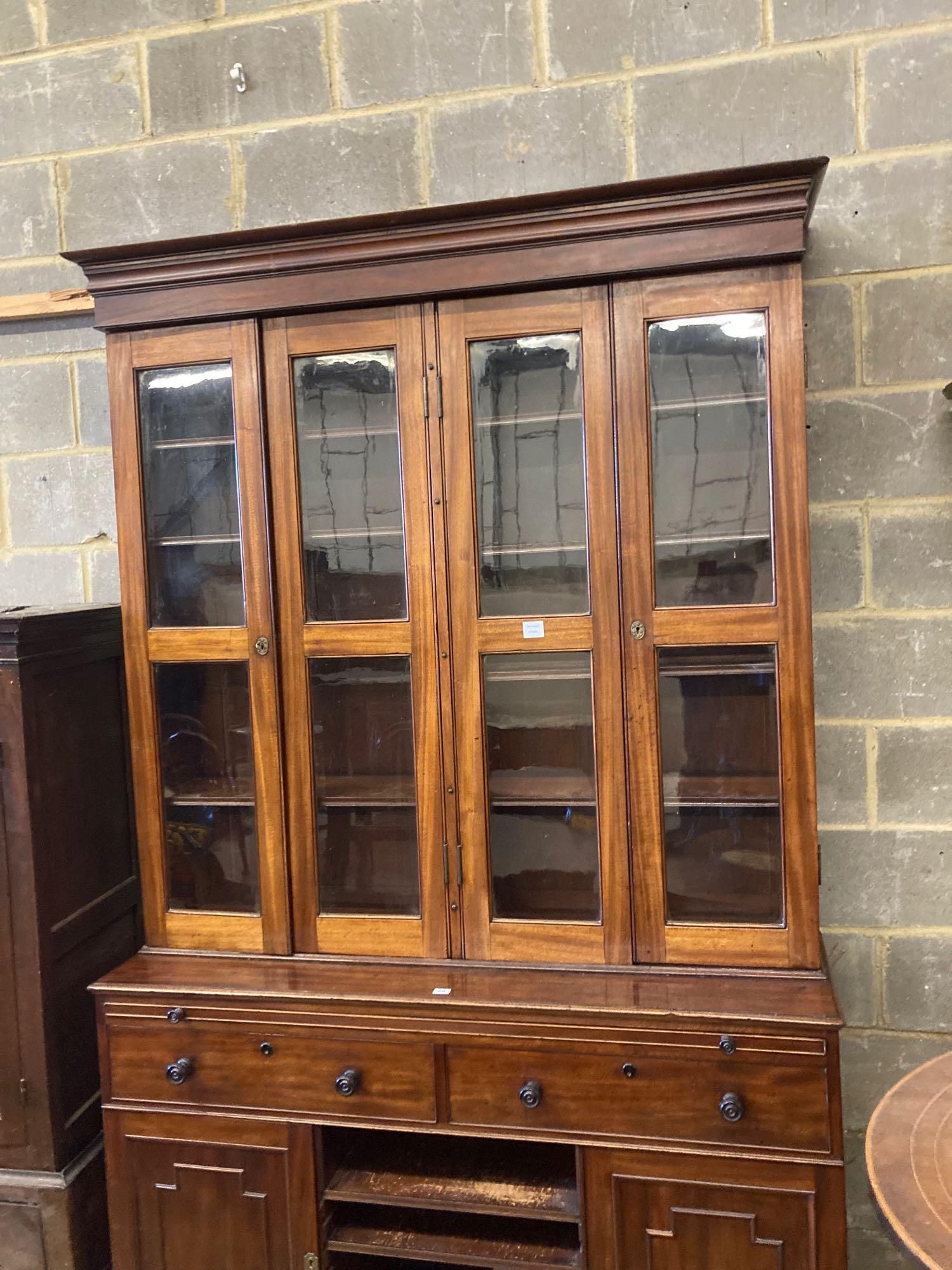 A Victorian mahogany bookcase cupboard, with pull out mid section writing slide, width 144cm depth 50cm height 245cm